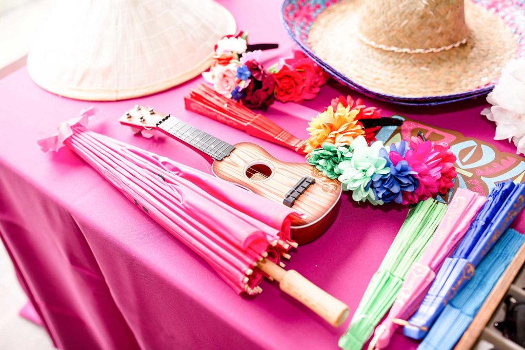 colorful props, Japanese umbrella, guitar, sombrero, flower crowns, fans display on a table