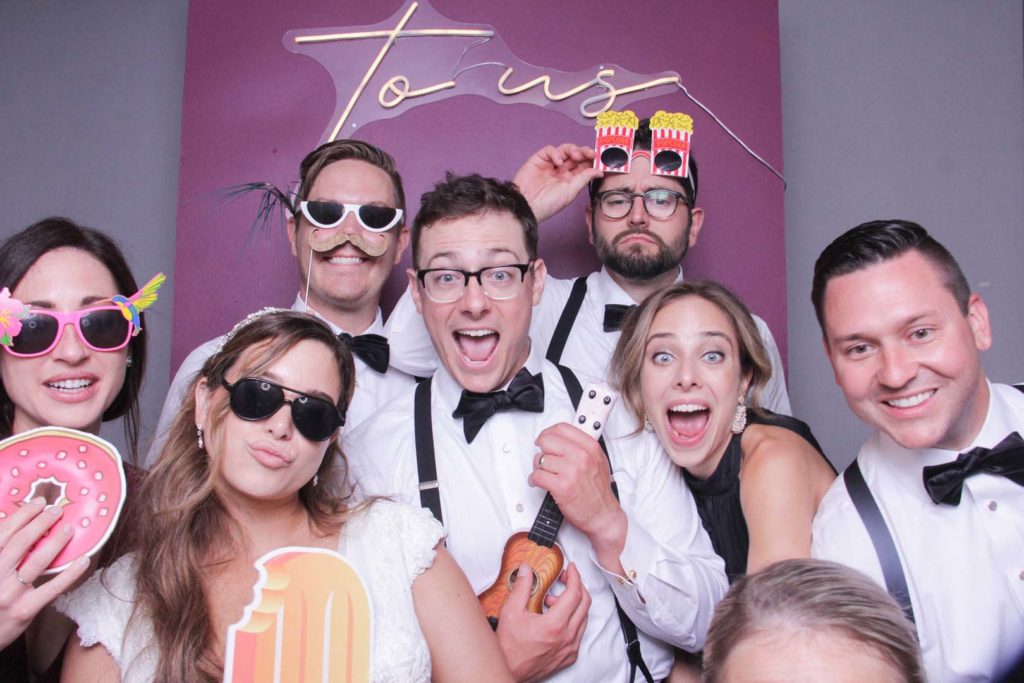group of people having fun at a wedding with a custom neon sign